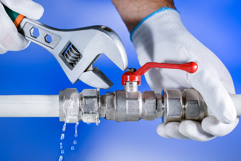 plumbing services; fixing plumbing pipe with a wrench