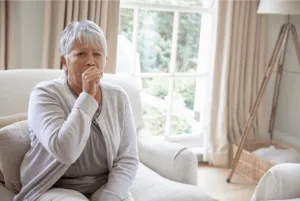 woman coughing in living room because air filter dirty